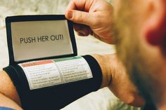 a man is holding an electronic device with the words push her out written on it