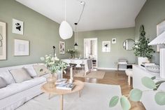 a living room filled with white furniture and green walls