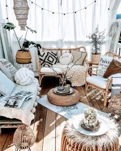 a living room filled with lots of wicker furniture and pillows on top of wooden flooring