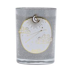 a glass candle holder with an image of the sun and clouds on it's side