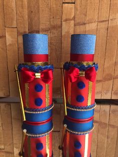 two red, blue and gold decorated candles with bows