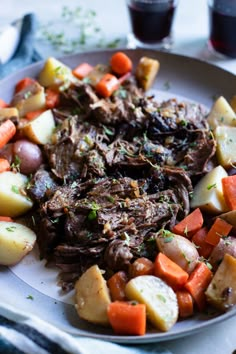 a white plate topped with meat, potatoes and carrots