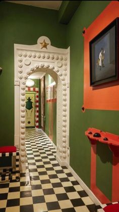 the hallway is decorated with black and white checkered flooring, green walls, and orange accents