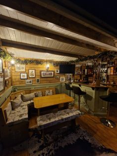 a room with couches, tables and pictures hanging on the wall above it's bar