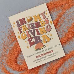 a flyer for an event with orange sprinkles on the ground next to it