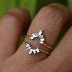 a woman's hand with two rings on it and one ring is made out of diamonds