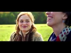 two women are smiling and standing in a field