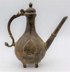 an old brass teapot with a handle