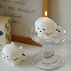 there is a small candle that has been placed on the table next to a bear figurine