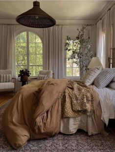 a bed room with a neatly made bed next to a window and a ceiling fan