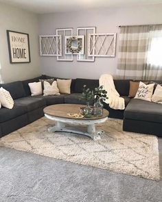 a living room with gray couches and white rugs on the floor in front of windows