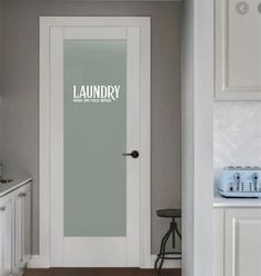 a white door with the words laundry on it in front of a kitchen counter and sink