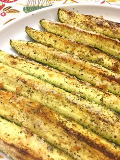 grilled zucchini on a white plate with parmesan cheese and seasoning