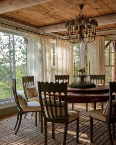 a dinning room table with chairs and a chandelier hanging from the ceiling