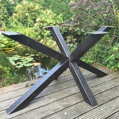 a metal sculpture sitting on top of a wooden deck next to a pond with water lilies