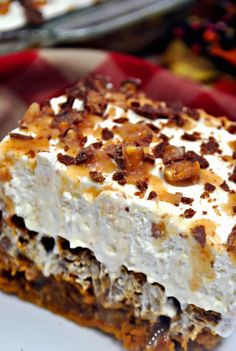 a piece of dessert sitting on top of a white plate next to a red and white checkered table cloth