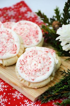 cookies with white frosting and sprinkles on a cutting board