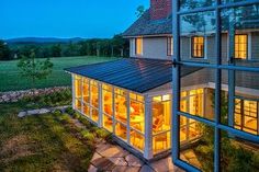 a house that is lit up at night with the lights on and windows showing outside