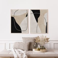 two paintings hang on the wall above a bench with pillows, vases and plants