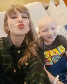 a woman holding a child in her lap and making a funny face while sitting on a hospital bed