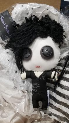 a stuffed animal with black hair and big eyes