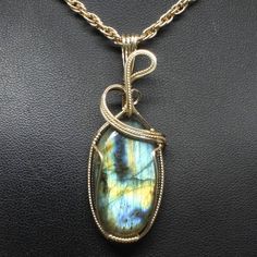 "Details About This Pendant: The contemporary stone pendant is hand crafted using fine precious metal wire and natural gemstone to form this stunning delicate enhancer. The bail is large enough to accommodate various styles of chains. It is not mass produced nor manufactured. *Natural Labradorite Gemstone (30mm x 20mm Oval Shaped). *Pendant Size: 2 1/4\" long including bail x 3/4\" at widest point. Includes free 18\" chain. *Precious metal is lead free, nickel free, does not tarnish. To protect Wire Pendants, Gemstone Pendants, Wire Wrapping Stones, Labradorite Necklace, Wrap Jewelry, Labradorite Jewelry, Labradorite Necklaces, Wire Pendant, Cabochons Stones