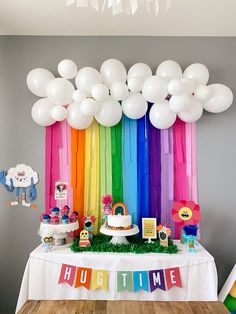 a rainbow themed birthday party with white balloons