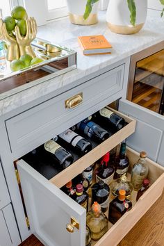 an open drawer in a kitchen filled with bottles