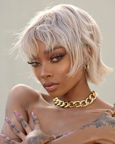 a woman with tattoos on her chest wearing a gold choker necklace and matching bracelet