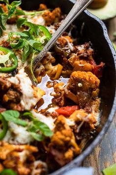 a skillet filled with meat and vegetables