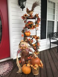 a porch decorated with pumpkins and fall decorations