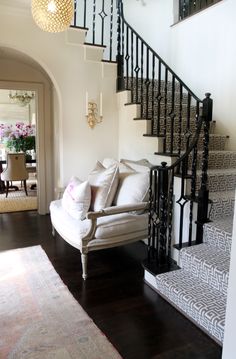 a living room filled with furniture and a stair case