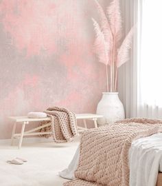 a bed room with a neatly made bed and a pink wall behind the headboard