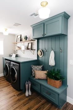 a washer and dryer in a laundry room with green cabinets, wood flooring and wooden floors