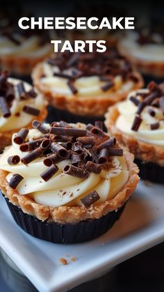 some cupcakes that are sitting on a plate with the words cheesecake tarts