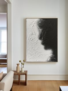 an abstract painting hangs on the wall in a living room