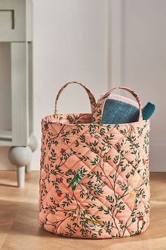 a pink basket with an embroidered design on it