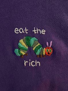 the very hungry caterpillar embroidered onto a purple t - shirt that says eat the rich