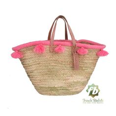 a straw bag with pink pom poms on the handles and bottom, is shown