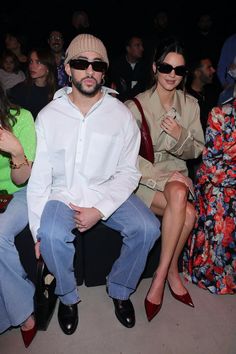 three people sitting next to each other at a fashion show