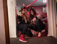 two women in red shoes are posing for the camera with lightsabens on their heads