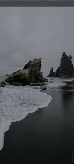 some rocks in the water on a cloudy day