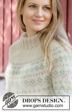 a woman wearing a sweater and smiling for the camera