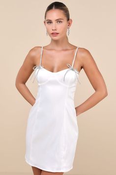 The Glamorous Bling Beauty White Satin Rhinestone Bustier Mini Dress will always make you the talk of any party! Super sleek woven satin shapes this flirty lil' dress that features a bustier-inspired design with seamed cups, a sweetheart neckline, and extra slender straps adorned with sparkling rhinestones and bedazzled bows at the front. The classic bodycon silhouette will effortlessly flatter your figure as it falls to a too-cute mini hem. Hidden back zipper/clasp. Fit: This garment fits true Rhinestone Bustier, Bustier Mini Dress, Adhesive Bra, The Talk, Strapless Bra, White Satin, Large Size Dresses, Sweetheart Neckline, Apparel Accessories