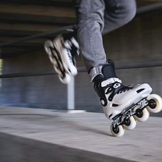 a person wearing black and white shoes is riding on a skateboard in the air