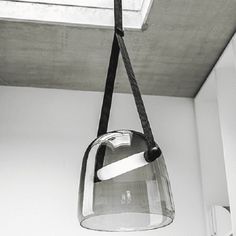 a light fixture hanging from the ceiling in a room with white walls and flooring