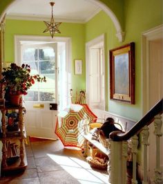 the sun shines through an arched doorway into a room with green walls and white trim