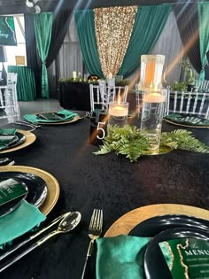 a black table with green and gold place settings