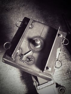 an old metal box with a wine glass on it's side and a bottle opener attached to the lid