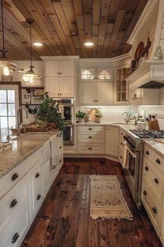 a kitchen with white cabinets and wood floors is pictured in this image, there are lights hanging from the ceiling